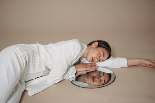 Woman Lying on the Floor Beside a Mirror