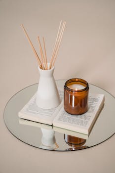 Serene still life of candle and incense on a book reflects tranquility and elegance.