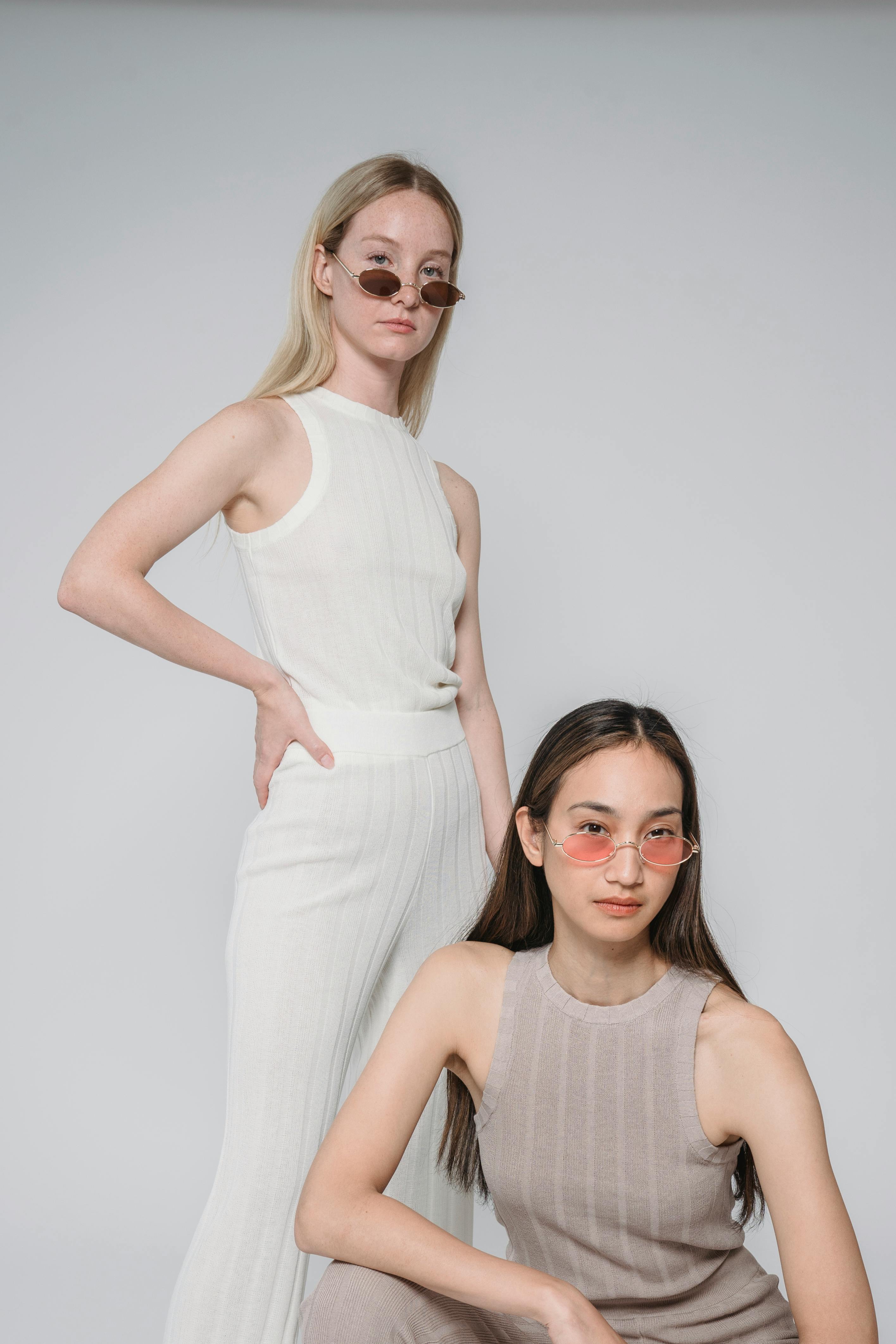 Bezpłatne Piękne Kobiety Pozujące W Modnych Okularach Przeciwsłonecznych Zdjęcie z galerii