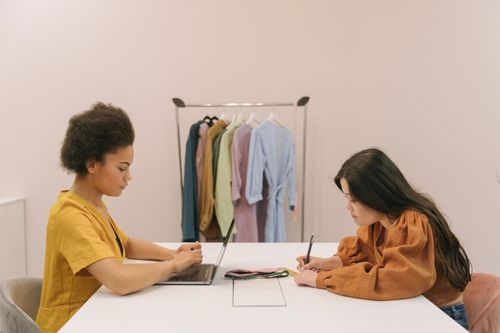 Free Two women working together in a fashion design office, focused on a project. Stock Photo