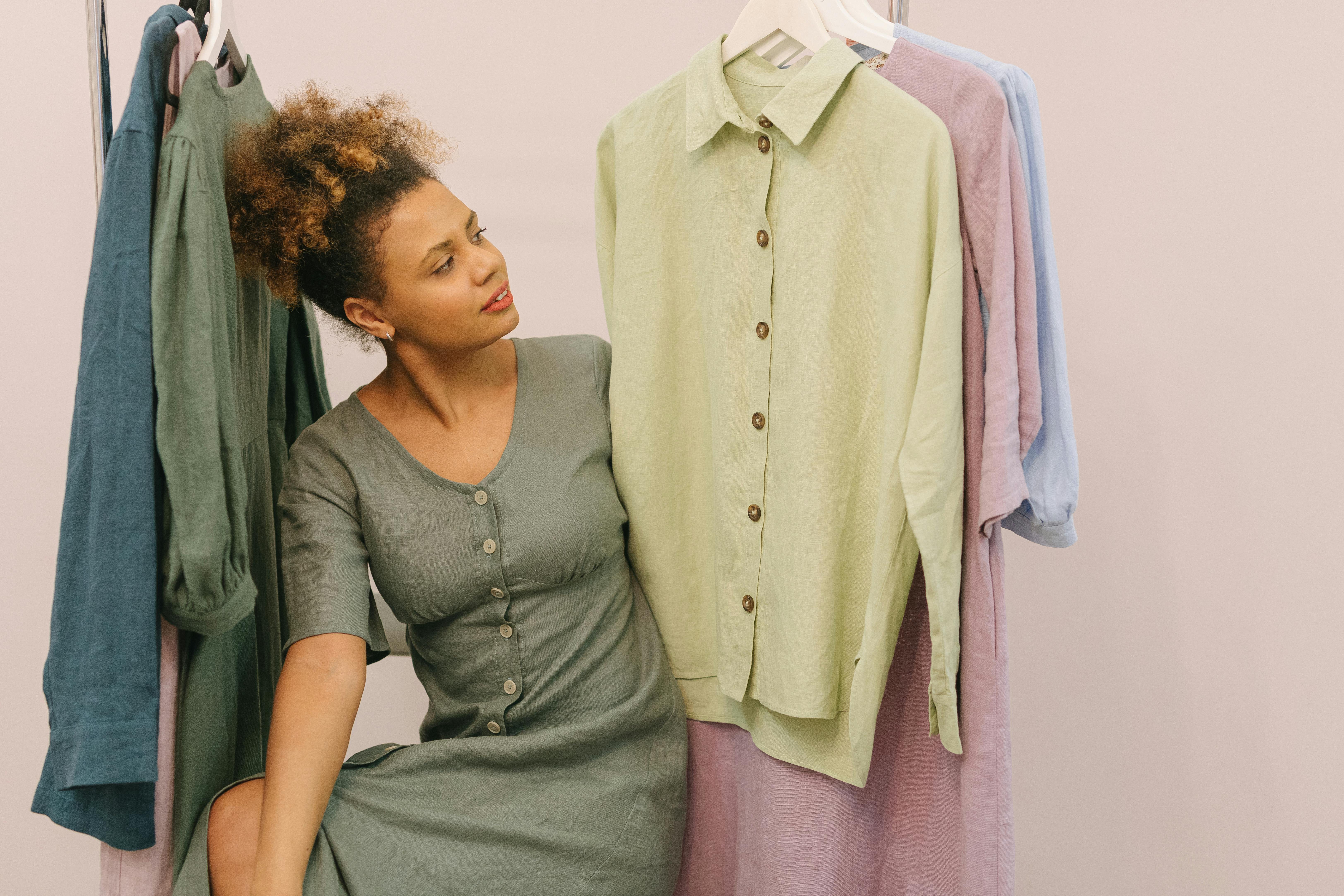 Beautiful Woman in Between Hanging Clothes · Free Stock Photo