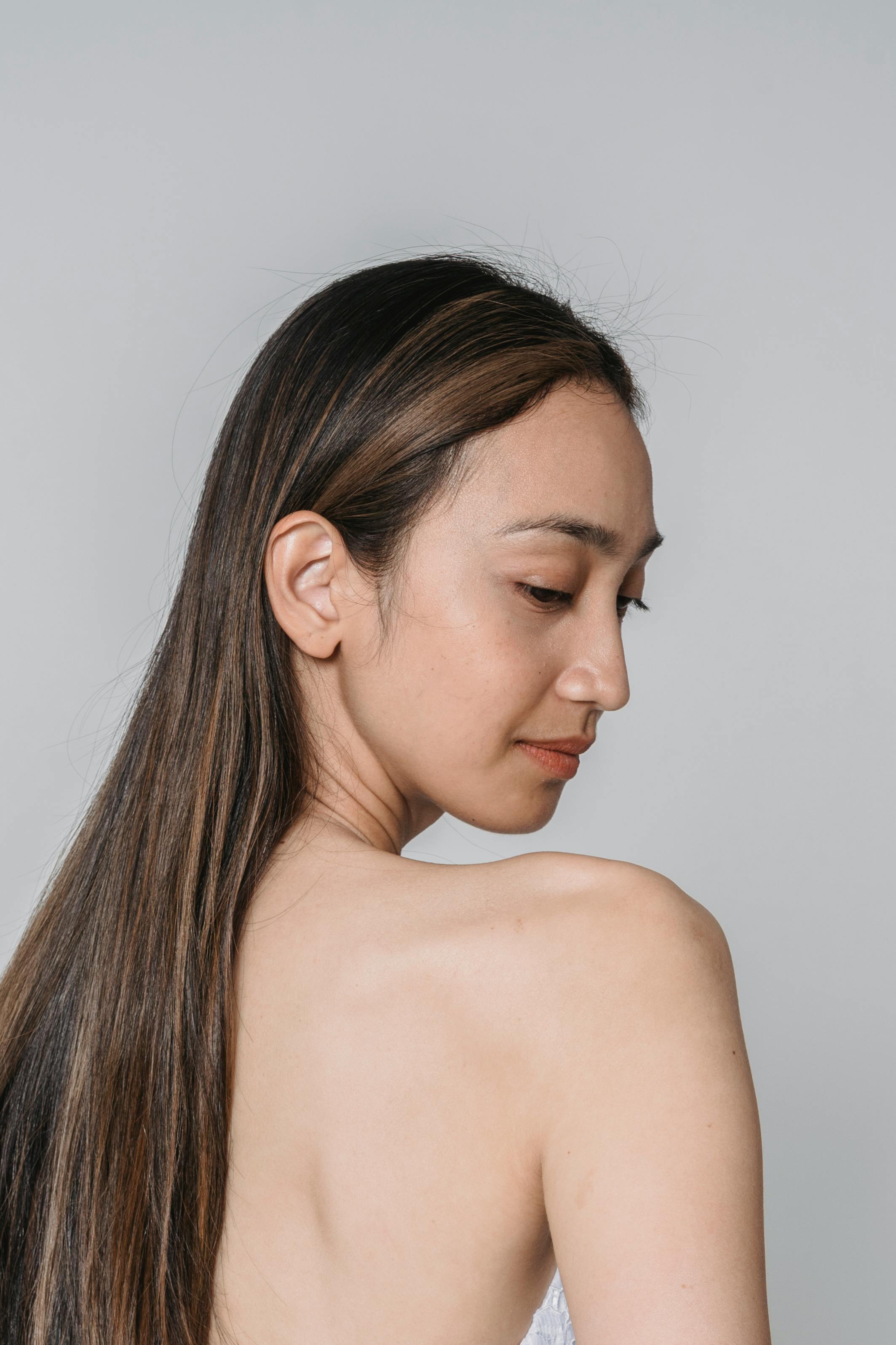 Side view of woman with long hair and smooth skin, showcasing natural beauty.