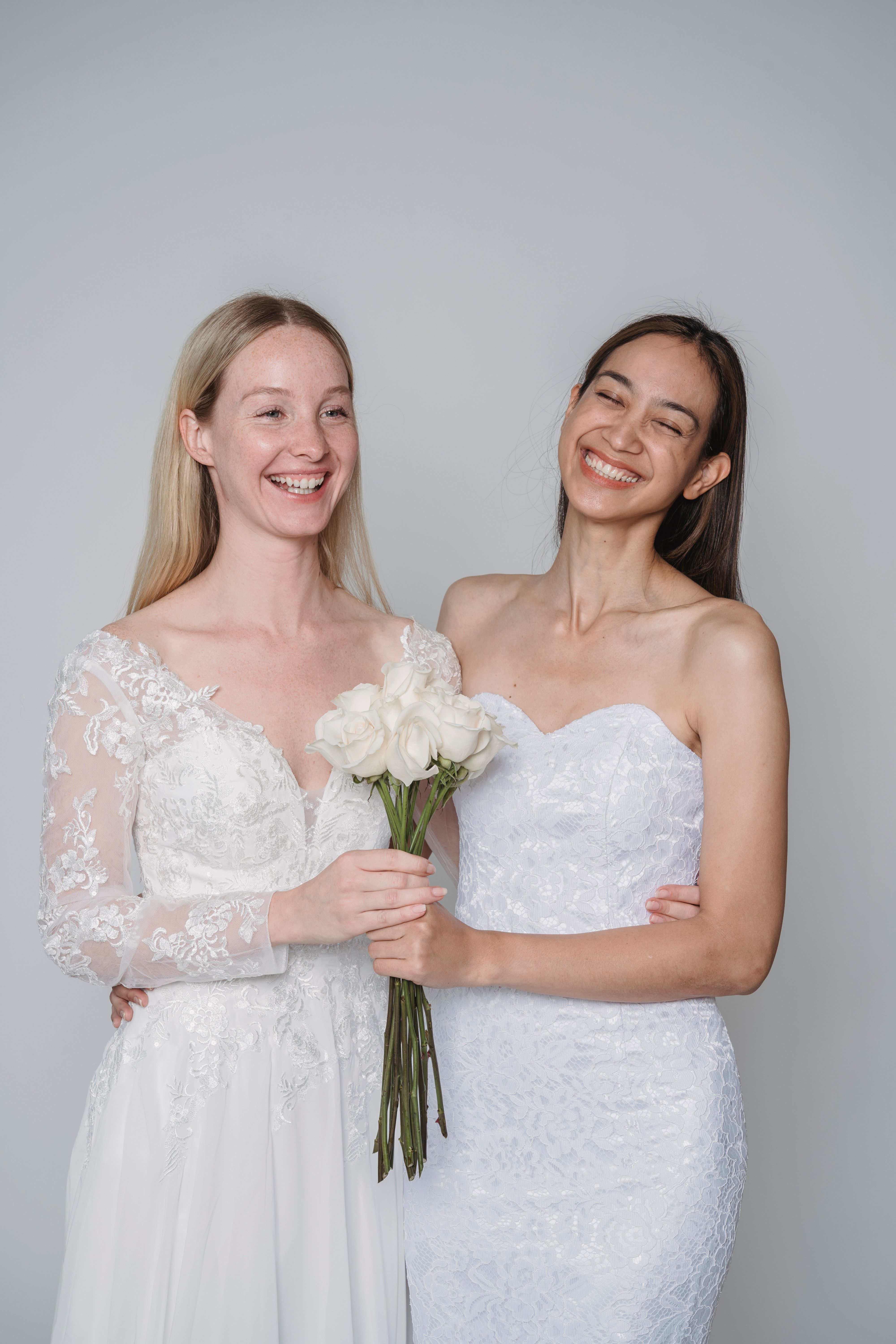 Beautiful Women in Wedding Dresses Holding a Bouquet of White Roses ...