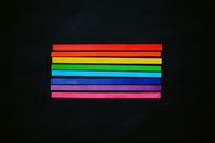 A simple, vibrant display of rainbow stripes on a black backdrop symbolizing diversity and pride.