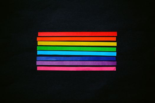 A simple, vibrant display of rainbow stripes on a black backdrop symbolizing diversity and pride.