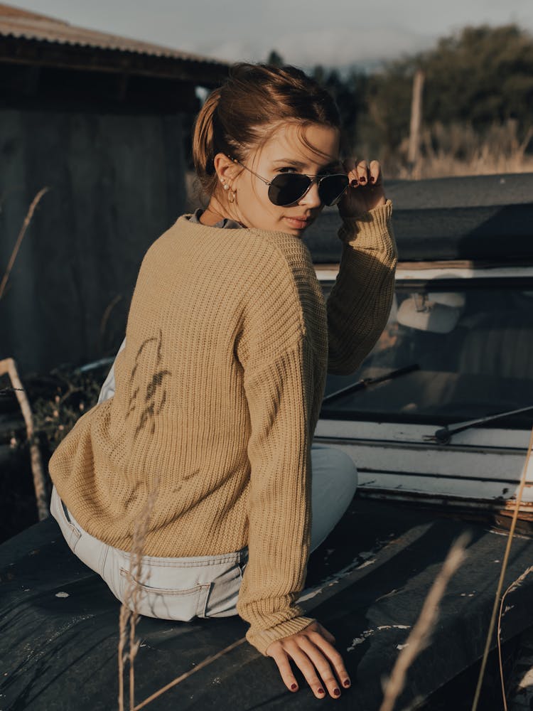 A Woman Sitting On The Hood Of A Jeep