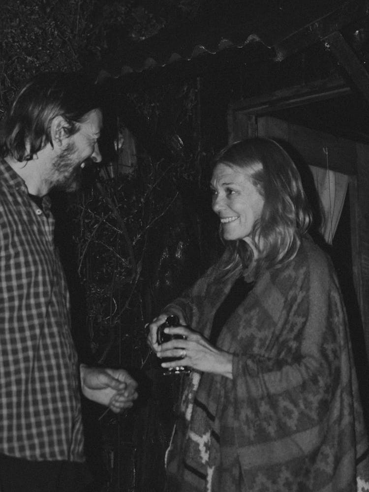 A Man And A Woman Talking Outside At Night