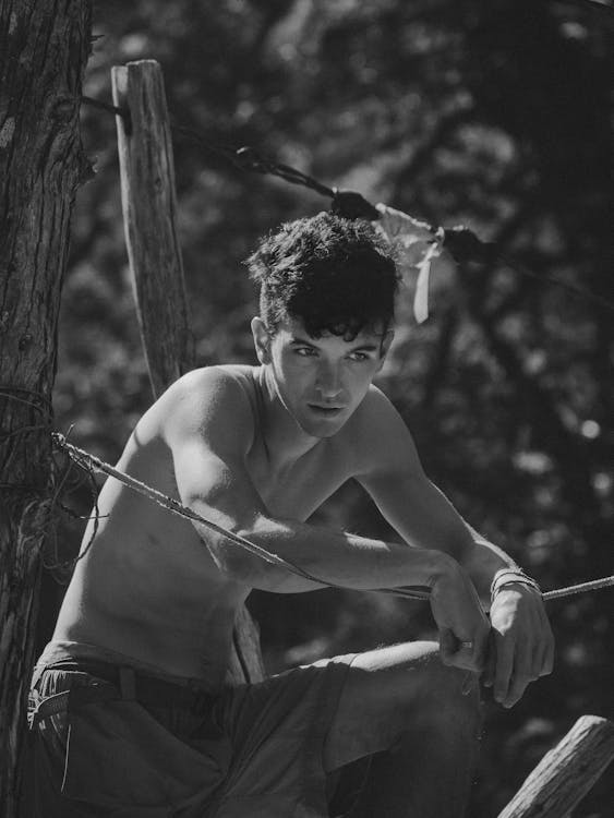 Monochrome Photo of Man Leaning on Rope
