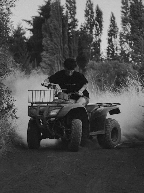 Monochrome Photo of Man Riding Atv