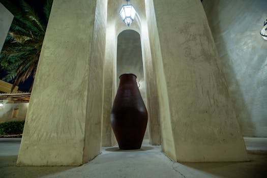 A clay jar and architectural pillars in Dubai, capturing a unique perspective at night.