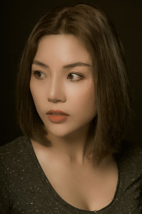 Free Portrait of an Asian woman gazing thoughtfully away, showcasing elegant makeup and hairstyle. Stock Photo