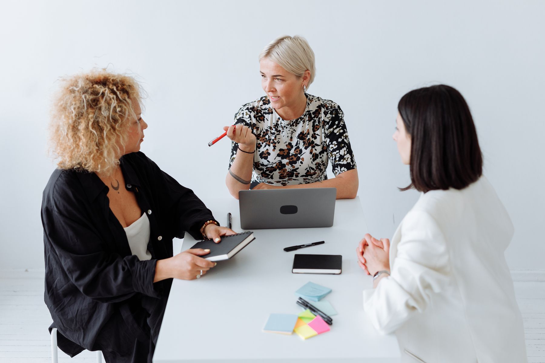 Three women discussing business plans around a laptop