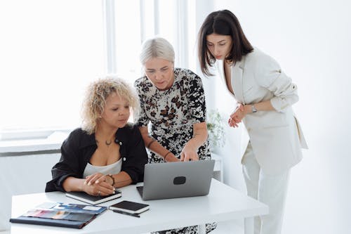 Free Group of Women Having Discussion Using the Laptop Stock Photo
