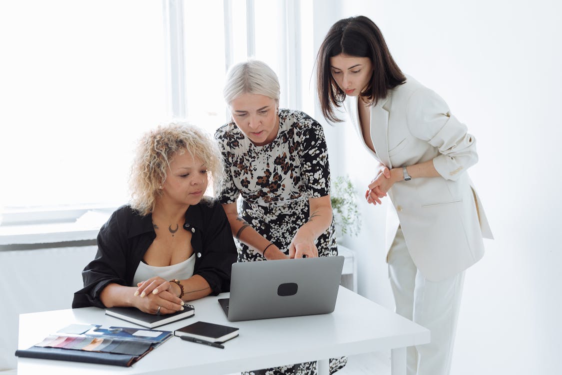 Free Group of Women Having Discussion Using the Laptop Stock Photo