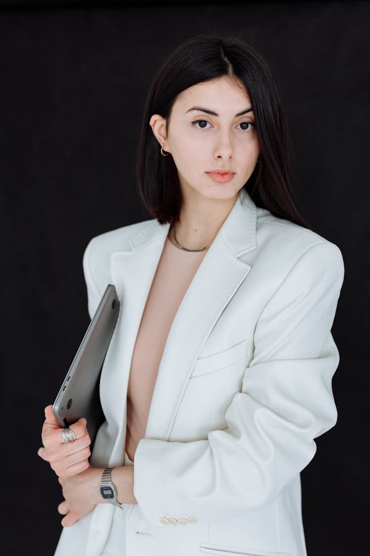 Woman In White Blazer Holding Silver Laptop