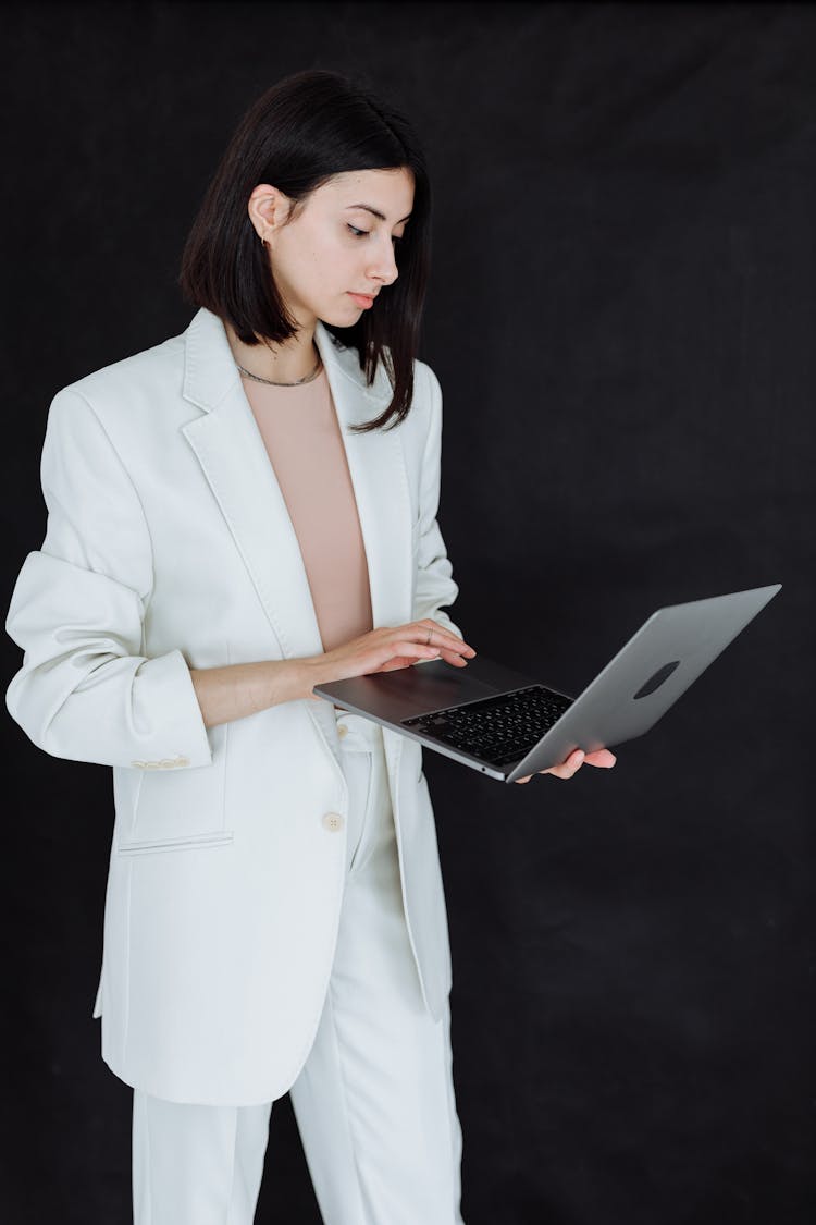 Woman In White Blazer Holding A Laptop