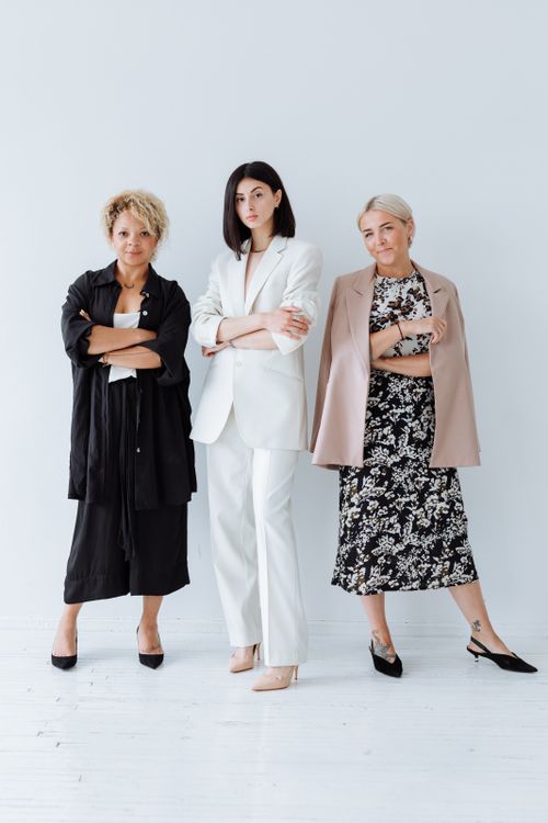 Free Three diverse women in stylish outfits posing confidently in a studio shoot on a white background. Stock Photo