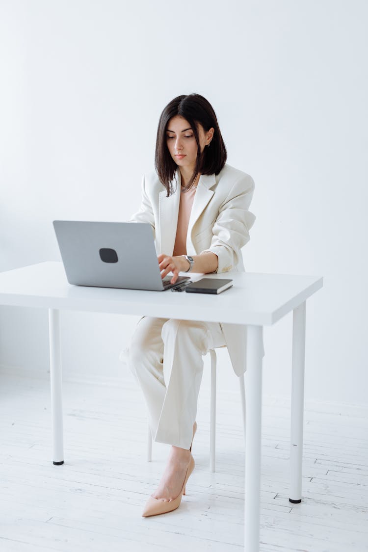 Beautiful Woman In White Blazer Using A Laptop