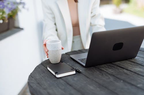 Closeup of a Woman Using a Laptop on a Garden Table