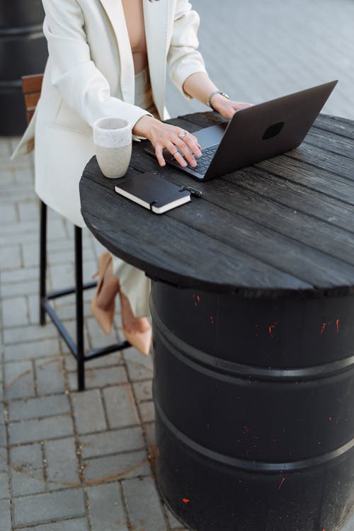 Free Woman Using Laptop on Wooden Table Stock Photo