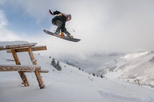 Free Man in Black Snowboard With Binding Performs a Jump Stock Photo