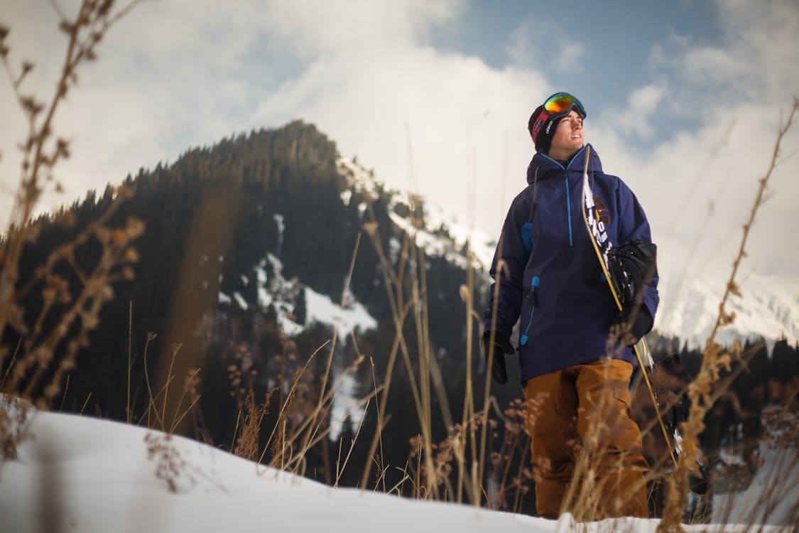 Lage Hoekfotografie Van Een Man Met Een Blauwe Jas Met Een Sneeuwbord