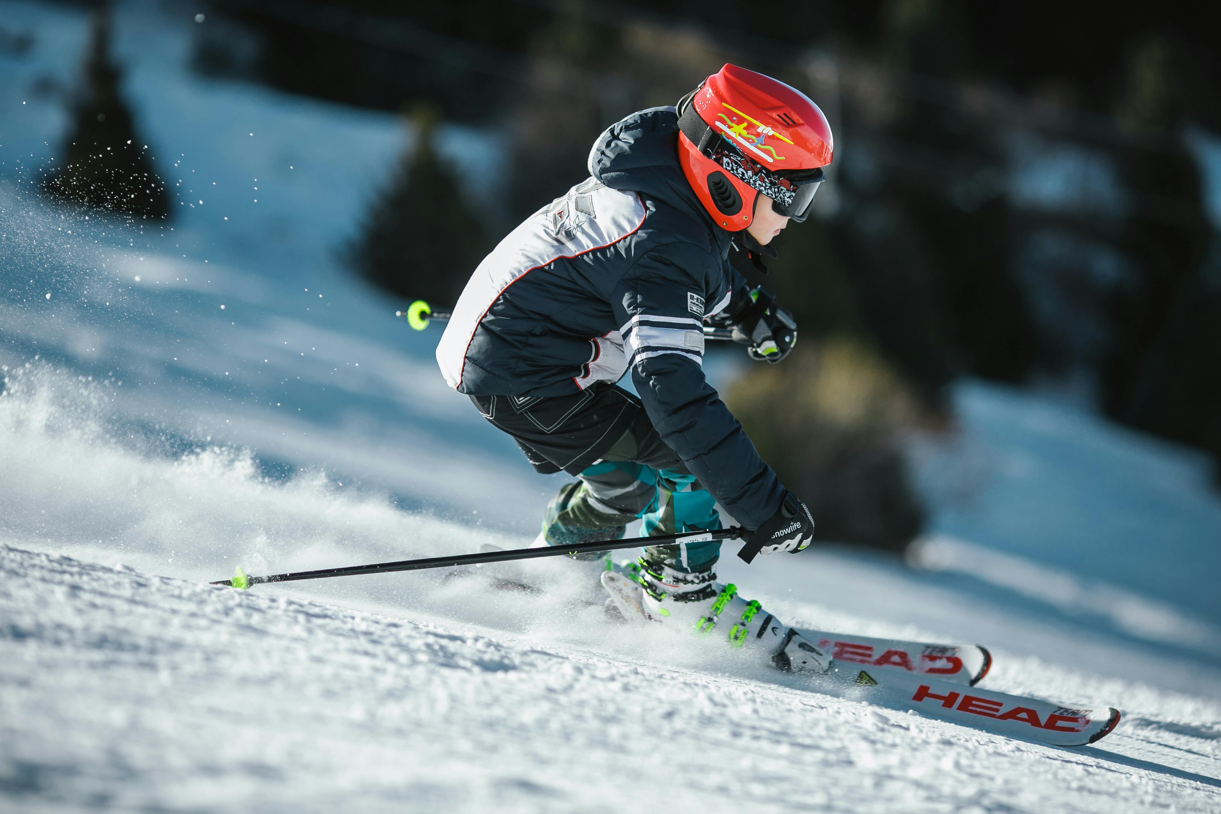 man doing ice skiing on snow field in shallow focus photography