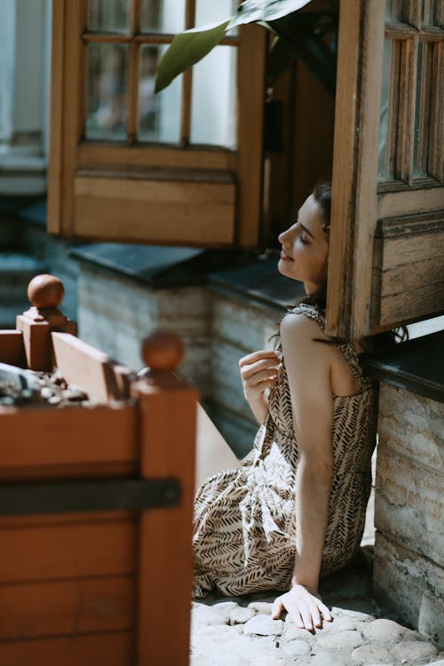 Darmowe zdjęcie z galerii z brązowa sukienka, kobieta, okiennice