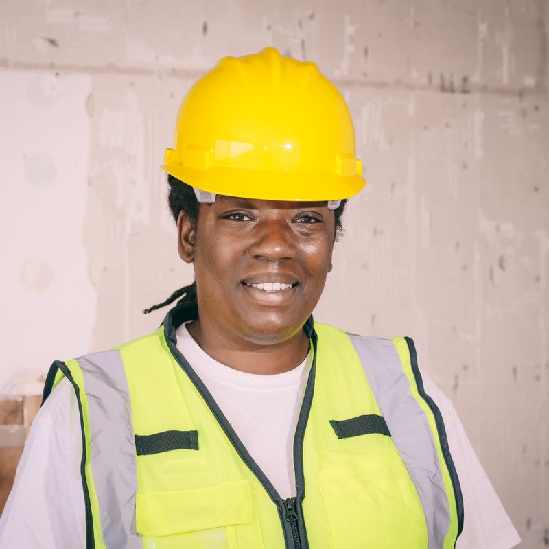 Crawl space technician in a yellow hard hat and safety vest