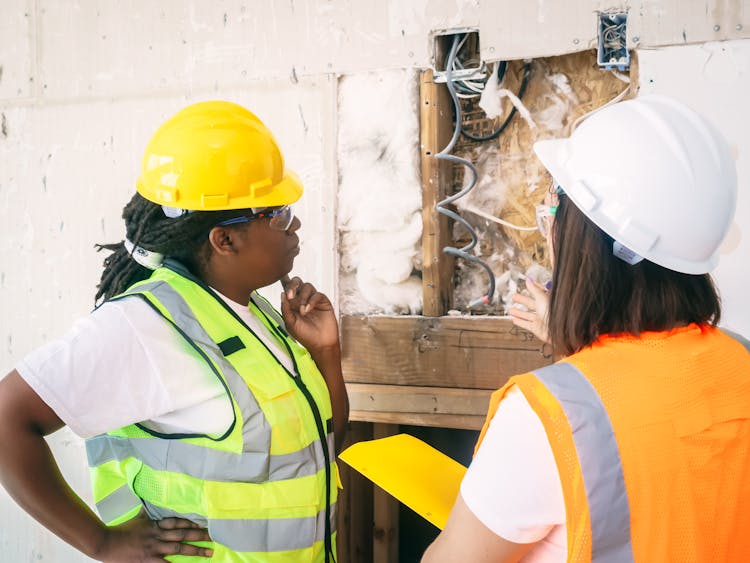 Female Engineer Looking At A Demolished Wall 