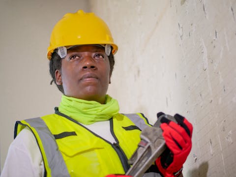 Professional plumber with spanner fixing pipes