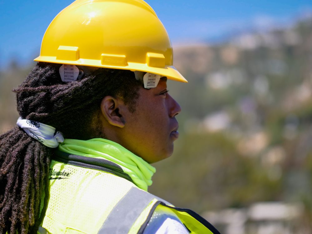 Professional construction engineer reviewing plans with safety equipment