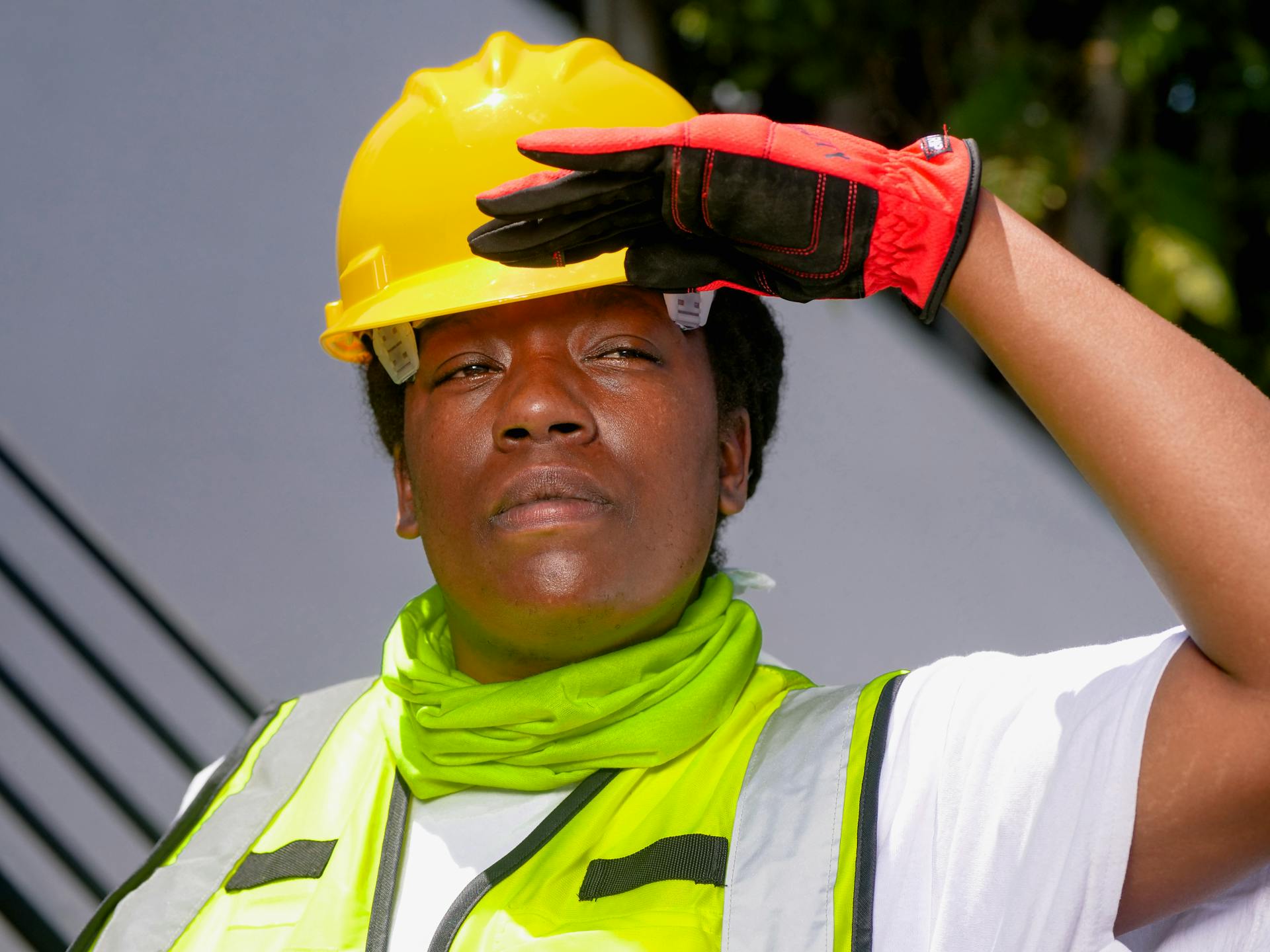 Confident female contractor wearing PPE and hardhat outdoors.