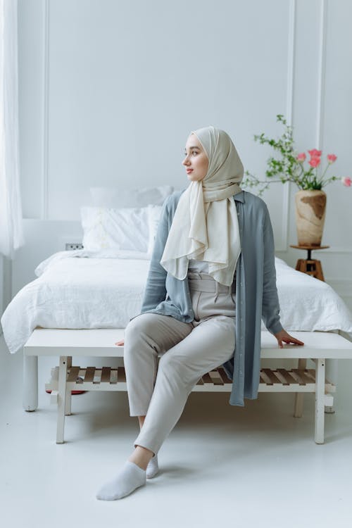 Woman in White Hijab Sitting on the Bed
