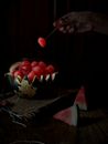 Person Holding Sliced Strawberries on Brown Wooden Table
