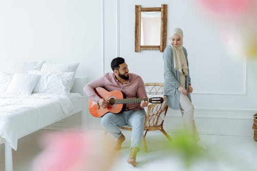 A Man Playing a Guitar with His Girlfriend