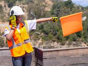 Handywoman Holding an Orange Signaling Flag