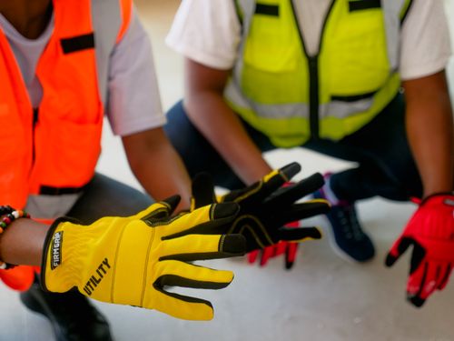 Free Close-up of two workers wearing protective gloves and reflective vests, focused on safety equipment. Stock Photo