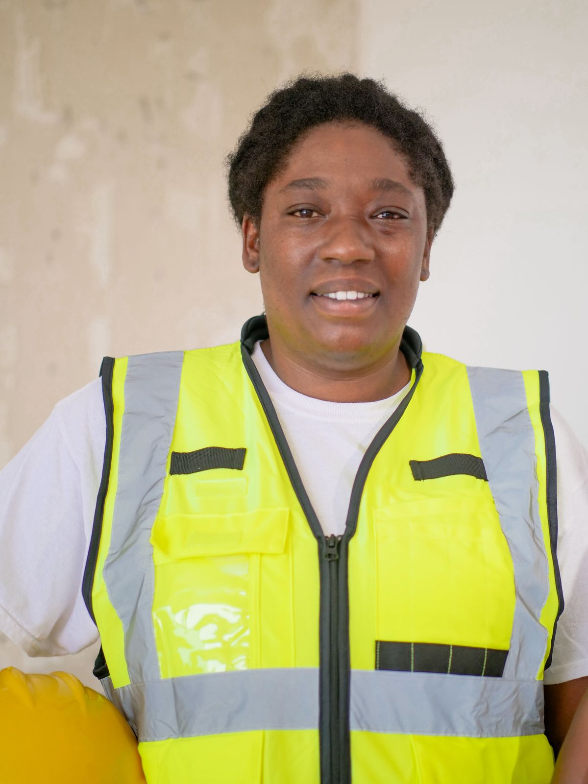 Portrait of a smiling construction worker wearing a reflective vest indoors