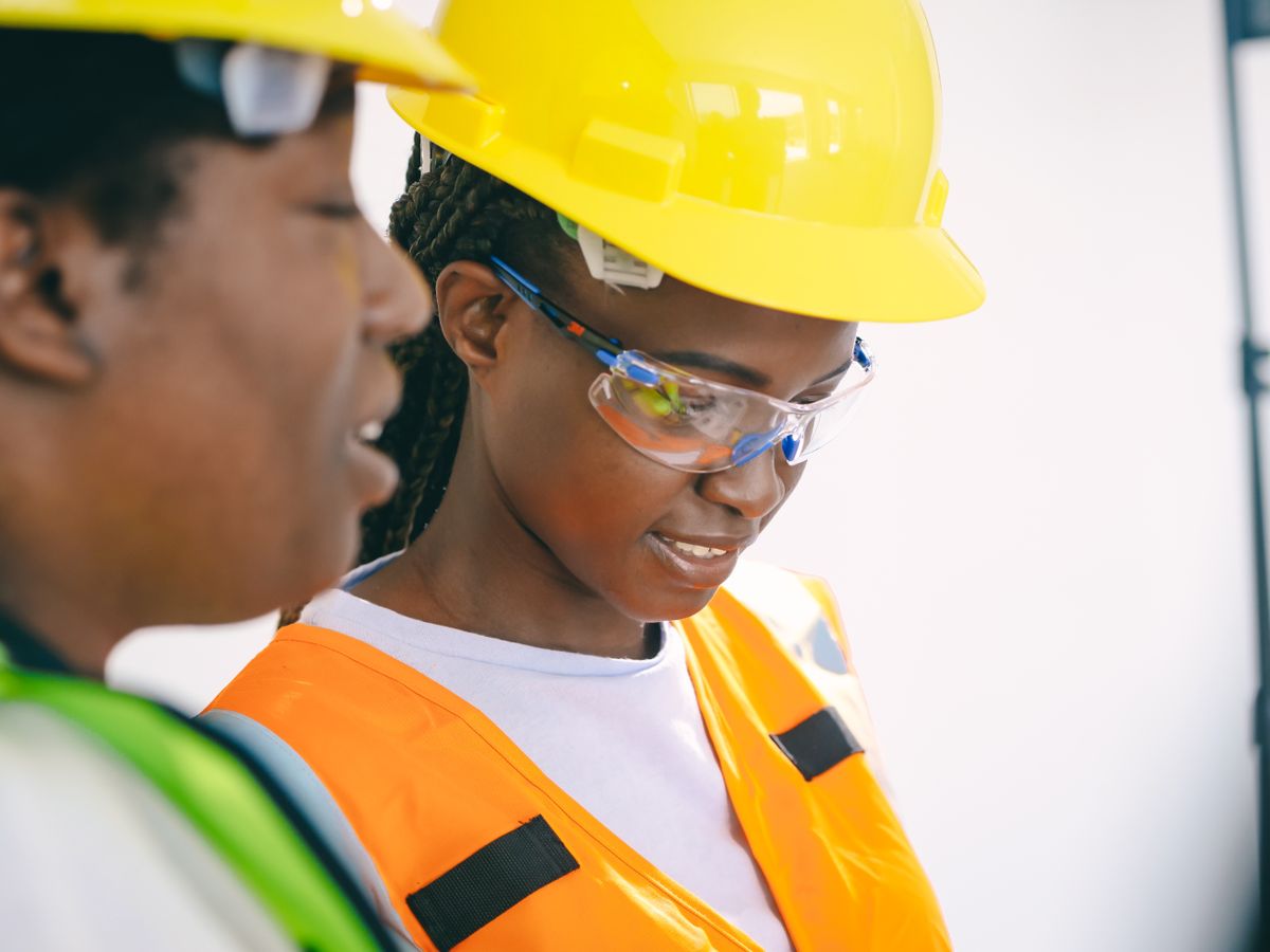 Workers in hard hats, safety glasses and reflective vests
