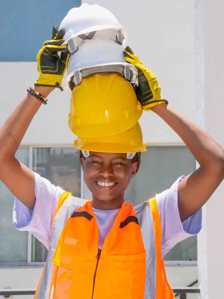 Smiling Woman With Stacked Hardhats In Her Head