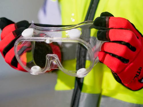 Free Person Holding Safety Glasses Stock Photo