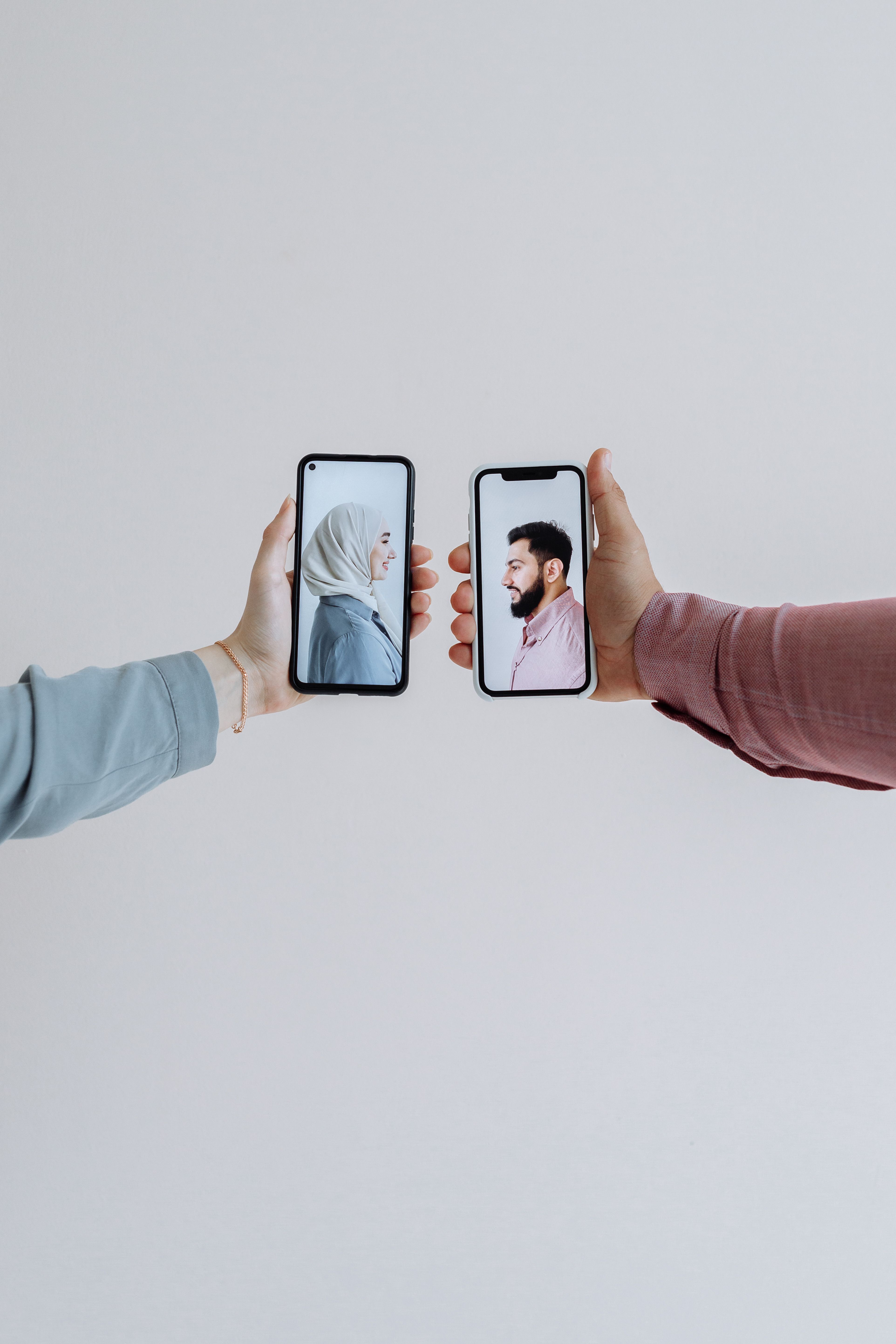 Two people holding smartphones with video call showing face-to-face communication.