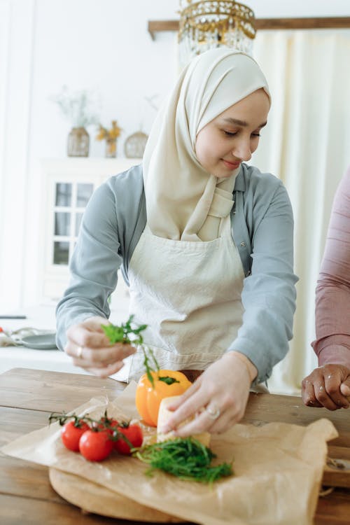 Woman in White Hijab Preparing Fresh Vegetables on the Wooden Table