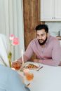 Man in Pink Sweater Sitting at the Table