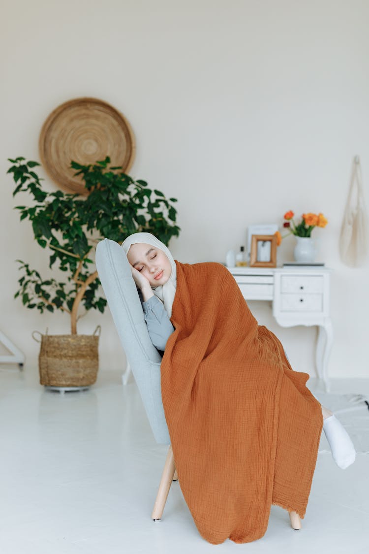 A Woman In White Hijab Peacefully Sleeping On The Chair 