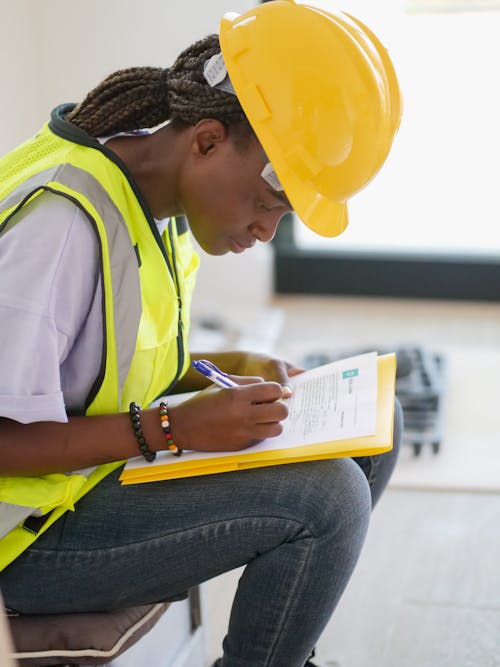 Free Woman Engineer Writing Down on Paper Stock Photo