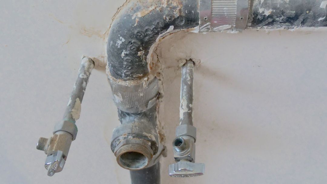Exposed metal pipes on a wall at a construction site