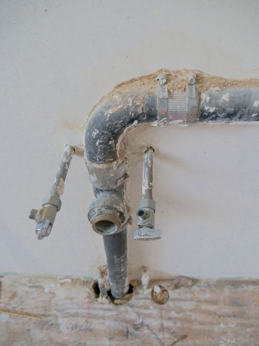 Professional plumber working under a kitchen sink