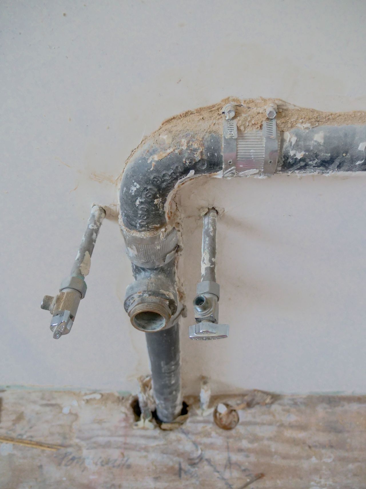 Neatly installed metal water pipes on a wall